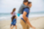 A happy family walking on a beach during the day.