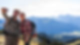 Smiling couple taking a selfie while hiking in the mountains.