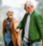 senior couple holding hand, and laughing as they take a walk