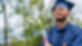 Smiling graduate in blue gown holding a diploma