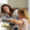 Woman and child at kitchen island with fresh vegetables