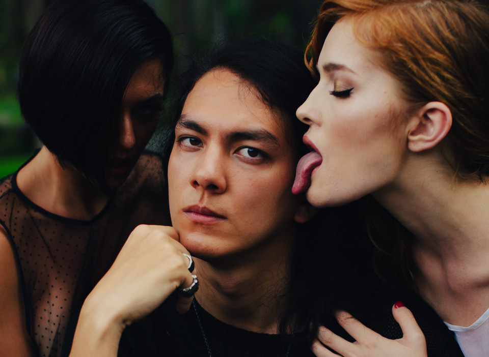 Photo from a Sensual Liberation Retreat in Bali showing Sami centered between two models one playfully extending her tongue symbolizing tension control and conscious sensual expression
