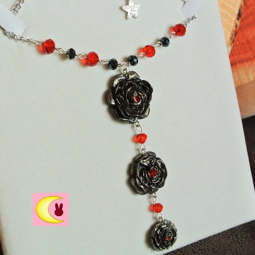 Thumbnail: Collier Black Roses sur fond blanc uni de loin