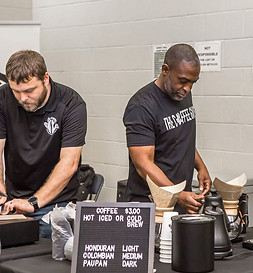 Trey (left) and McKendrick (right) at an event making pour over coffee using Chemex brewers