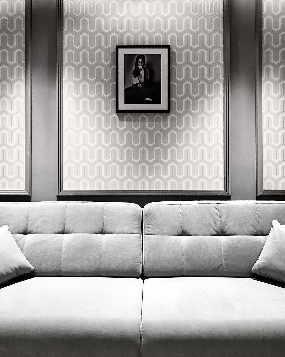 Elegancki salon w szarych tonacjach, wpisany w geometryczne linie wnętrza historycznej kamienicy.