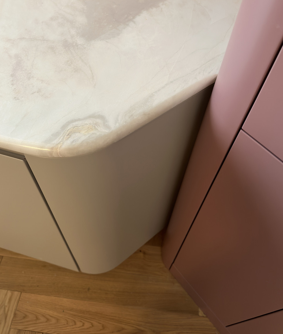 Elegancka kuchnia z subtelnymi różowymi frontami i naturalnym marmurem, idealnie komponującymi się z nowoczesnym designem wnę