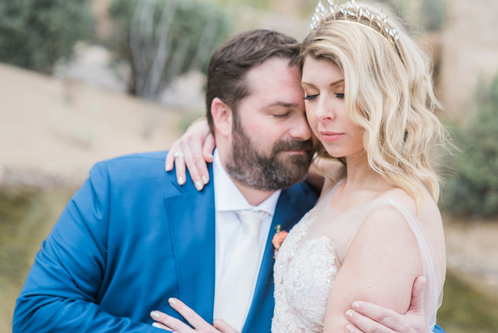 Romantic shot of bride and groom by Savannah and destination wedding photographer, groom in navy blue suit, bride with tiara