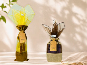 Beauty Blisss reusable fabric gift bag and wine bag with organza wrap fillers and kraft tags in a soft natural setting