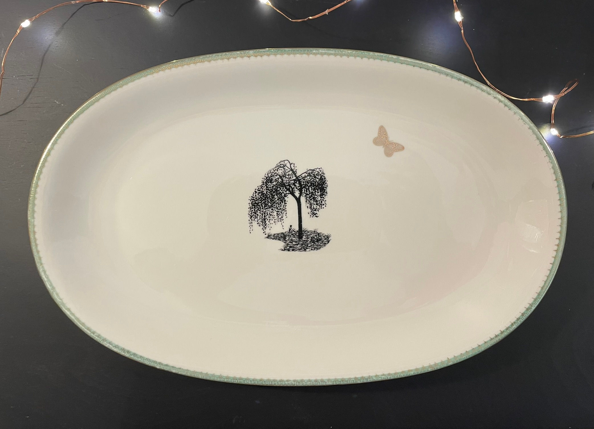 Un plat vintage ovale avec bordure vert pale upcyclé avec bouleau pleureur et papillon doré