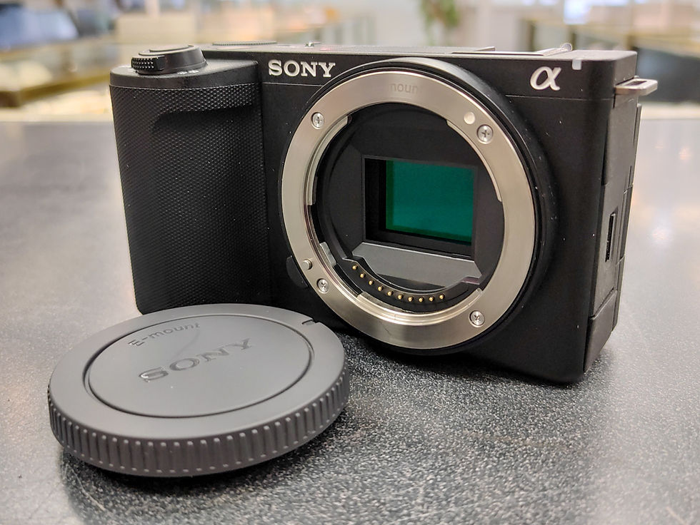 Thumbnail: Sony ZV-E10 II black mirrorless camera body with E-mount body cap, flip-out screen, clean sensor area, original Sony battery