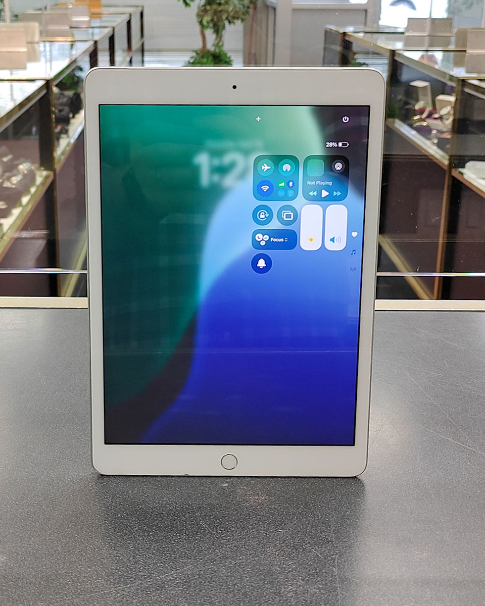 Apple iPad 7th generation 10.2-inch A2198 in silver with white bezel, showing active screen and minor cosmetic wear on back