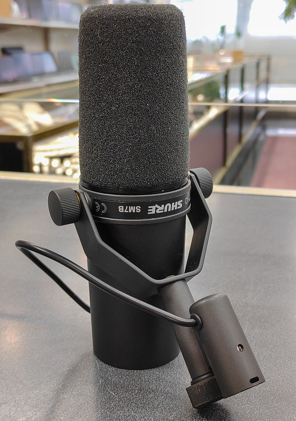 Thumbnail: Shure SM7B XLR dynamic microphone with yoke mount, foam windscreen, rear controls, and XLR connector.