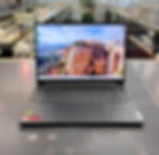 Lenovo Slim Pro 7 14" laptop open on counter showing keyboard and edge-to-edge display; charger pictured separately