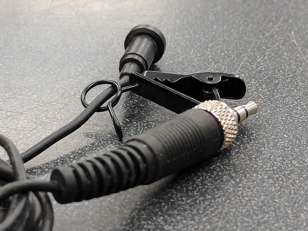 Unbranded lavalier microphone with clip, black cable, and 3.5 mm TRRS connector coiled on tabletop
