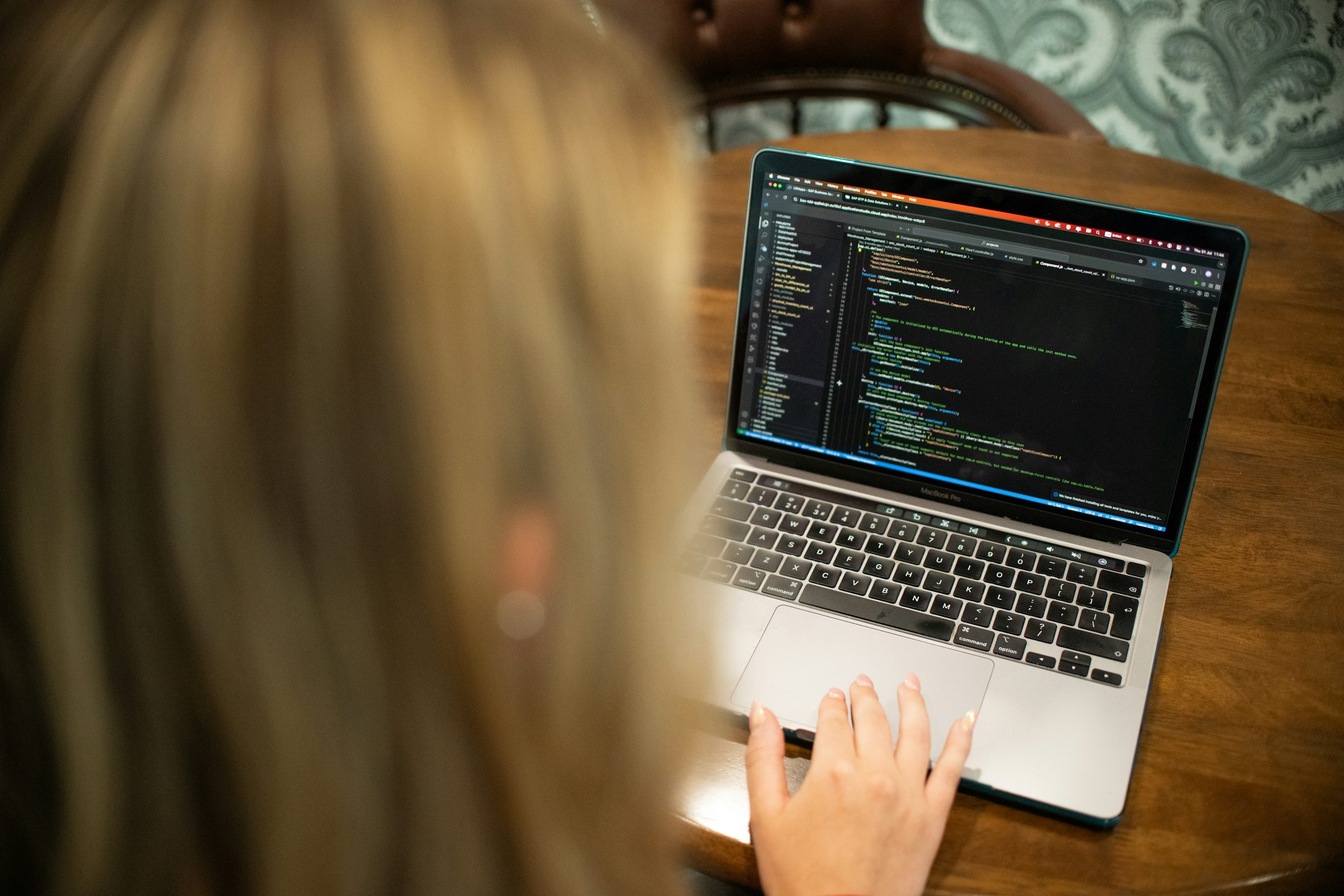 Woman typing code on a laptop computer, illustrating independent examination of technology