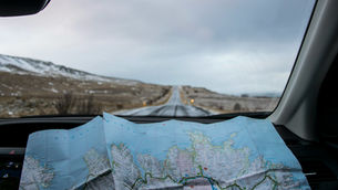 A quiet road curving through hills, seen through a windshield