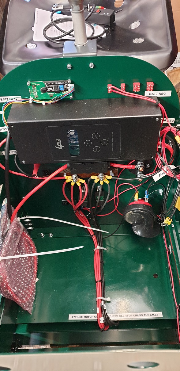 Wiring and electrical equipment inside the green auto truck.
