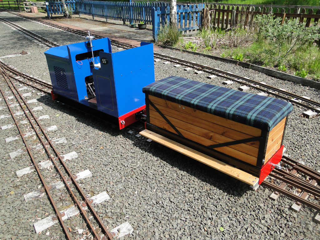 Rear view of blue Phoenix Tug miniature locomotive and matching timber-bodied driving truck