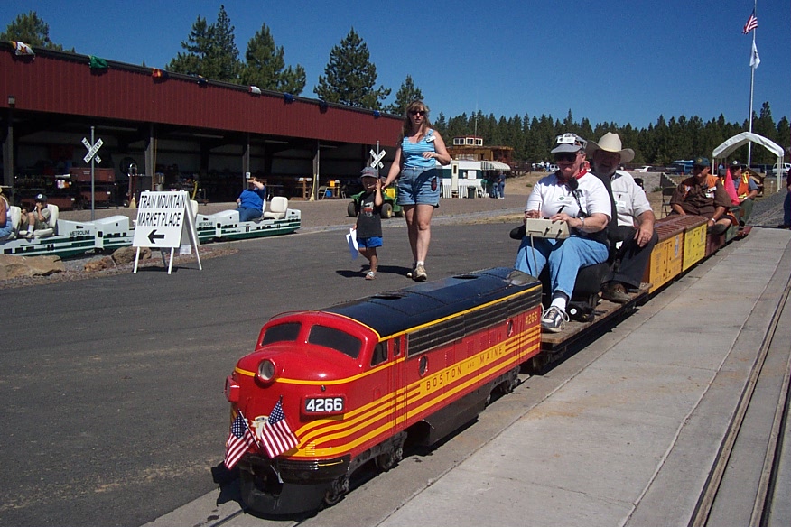 Red and black Boston and Maine F7 miniature locomotive No. 4266 hauling passengers at an American miniature railway
