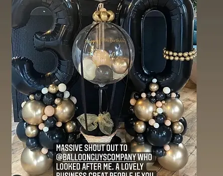 leon mckensize celerbating his daughters 30th birthday with large 30 black balloons 