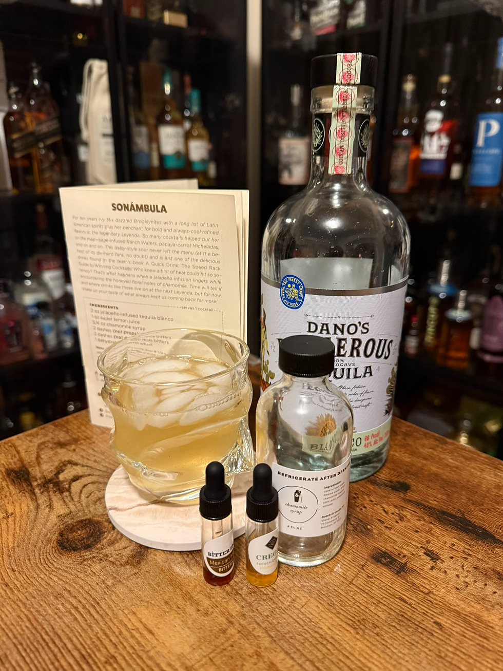 Cocktail setup on a wooden bar: tequila bottle, chamomile syrup, bitters, ice-filled drink, and recipe card labeled SONÁMBULA.