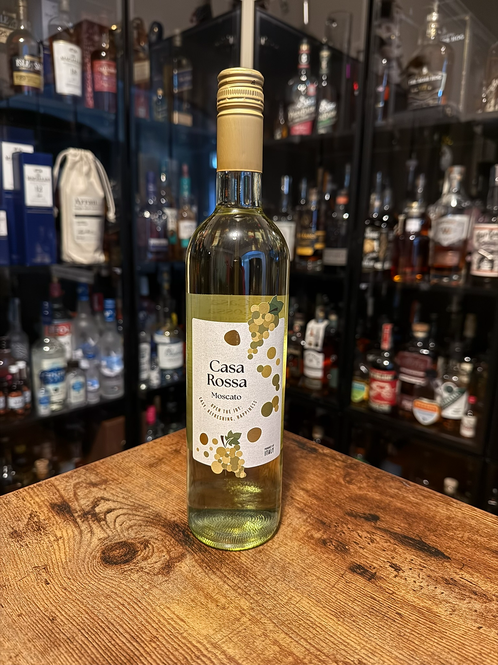 Casa Rossa Moscato bottle on a wooden table, with liquor bottles blurred on shelves behind it.