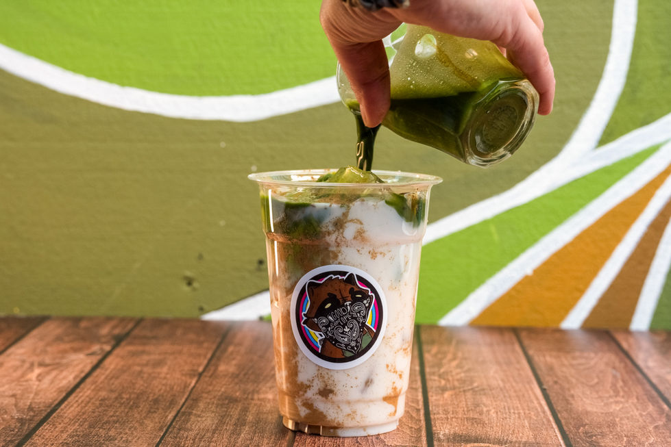 a person pouring green liquid into a plastic cup