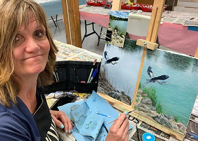Students engaged in an art class at Norwin Art League, painting at tables in a bright and creative studio environment.