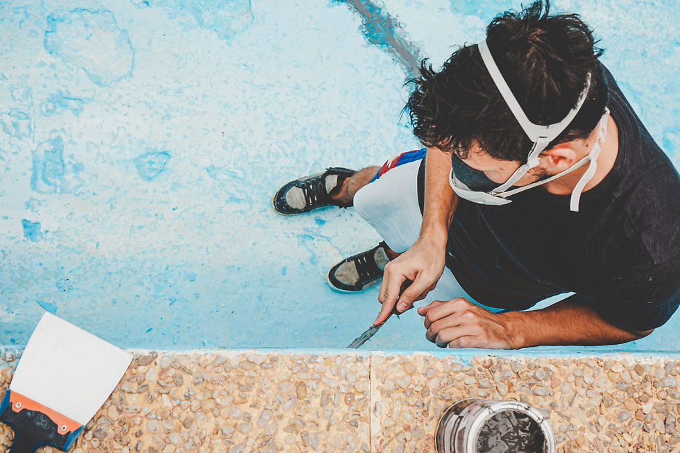 Eye-level view of a pool tradesperson inspecting the inside wall of a drained concrete pool.