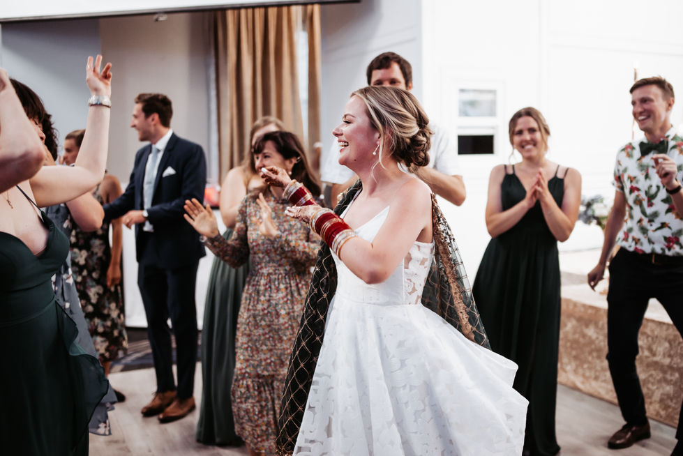 a woman in a white dress is dancing with a group of people