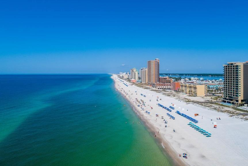 Aerial view of Gulf Shores, Alabama with sugar-white sand, turquoise Gulf water, and beachfront condominiums.