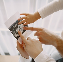mom-dad-daughter-watching-ultrasound-picture-baby-family-light-clothes-family-expecting-ba