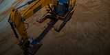 Excavatrice jaune sur un chantier de construction.