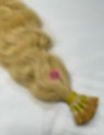 Blonde wavy I‑Tip Remy hair extensions close up