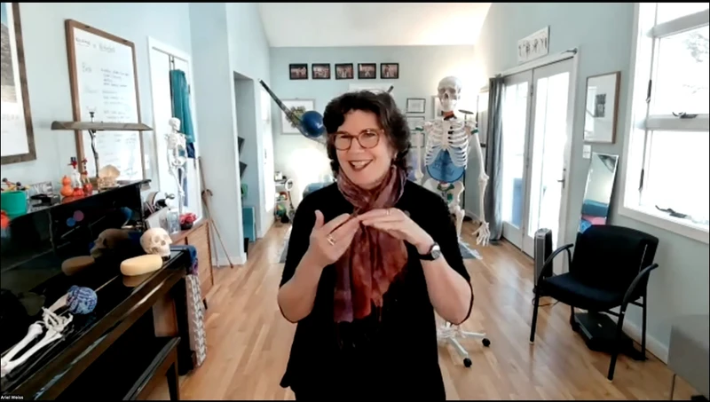 Ariel Weiss facing camera and teaching a Zoom class on hand position.