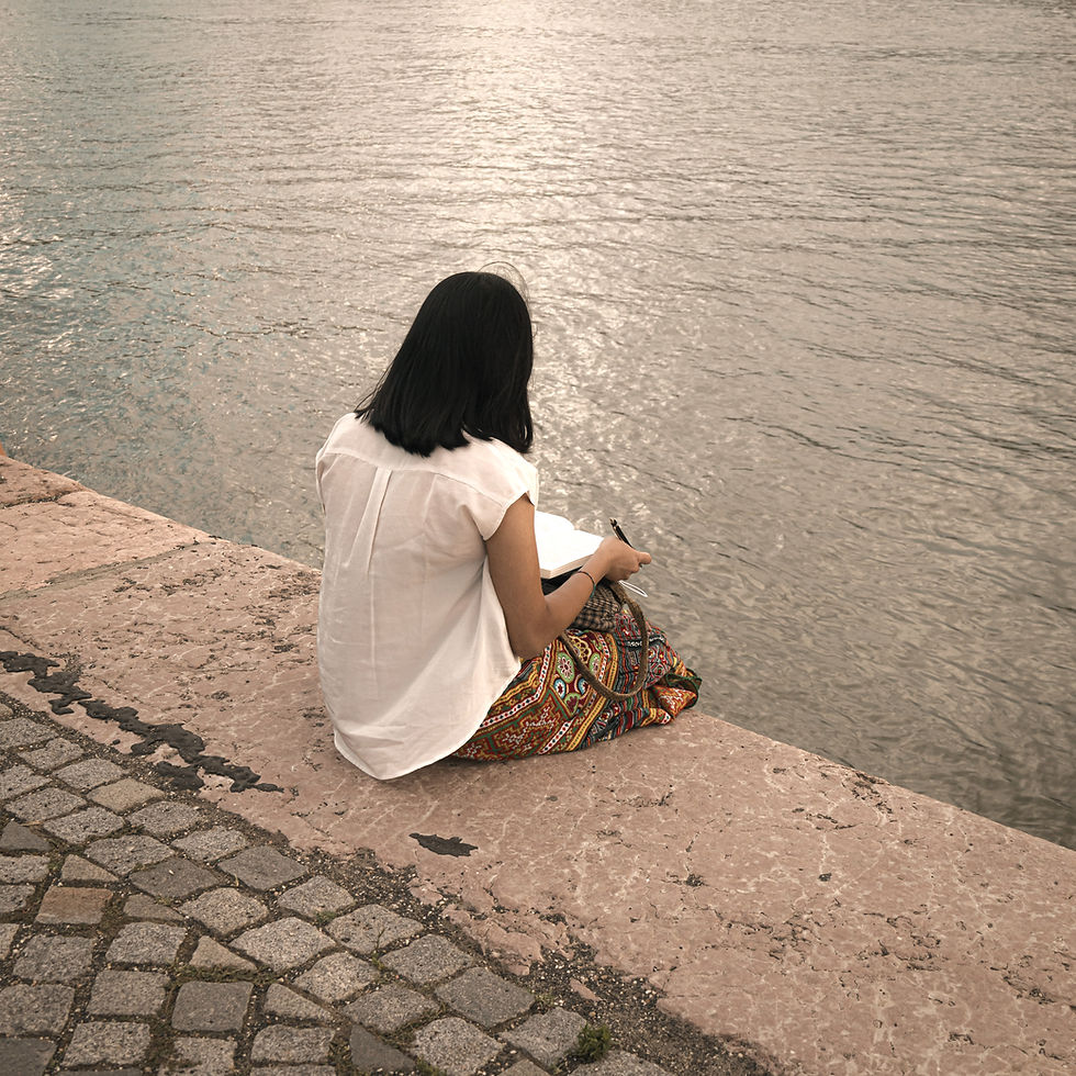 Adult sitting quietly by a river reflecting on their mental health journey