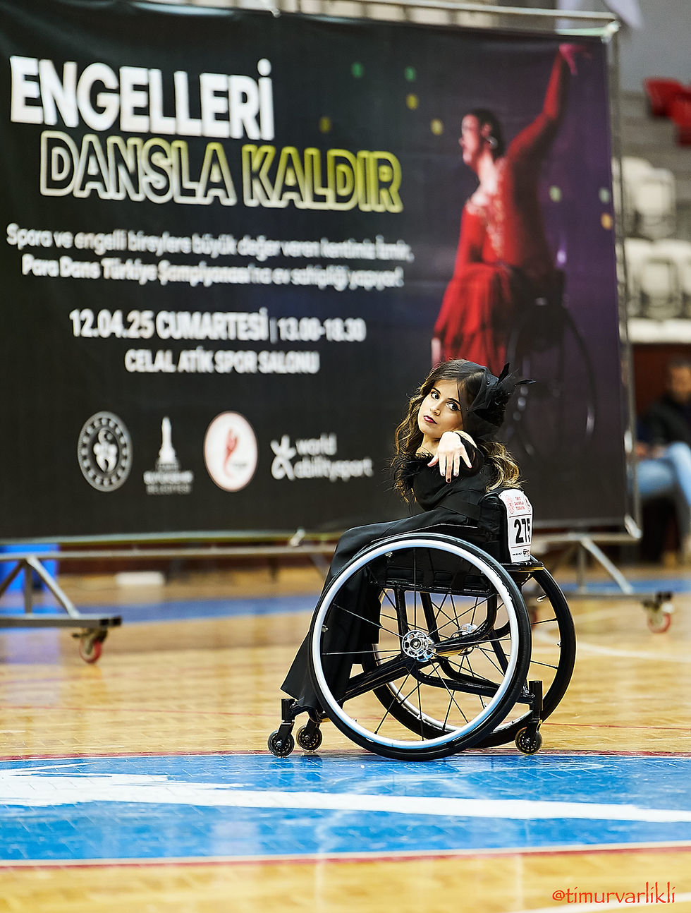 Tekerlekli sandalyede dans eden sporcu ve Paradans afişi