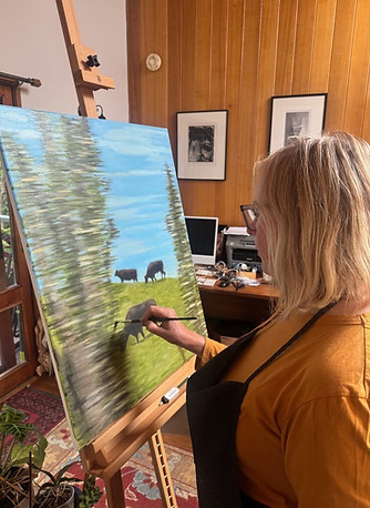 Kate painting 3 cows on a hill.jpeg