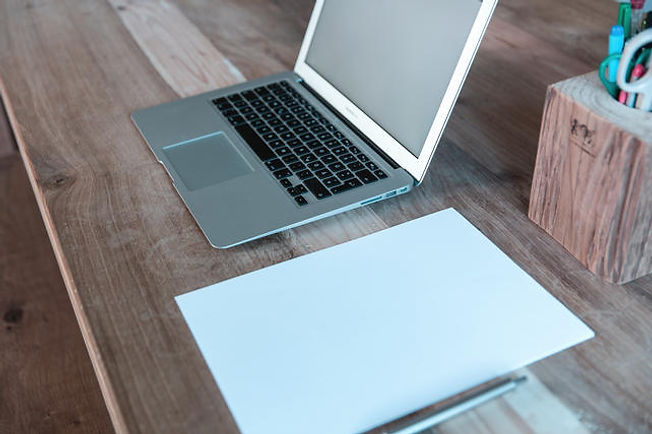 Laptop and paper on desk.