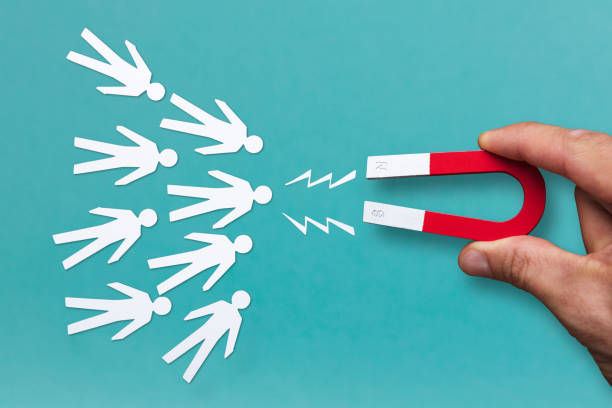 magnet in the man's hands draws emarginate cutouts of people
