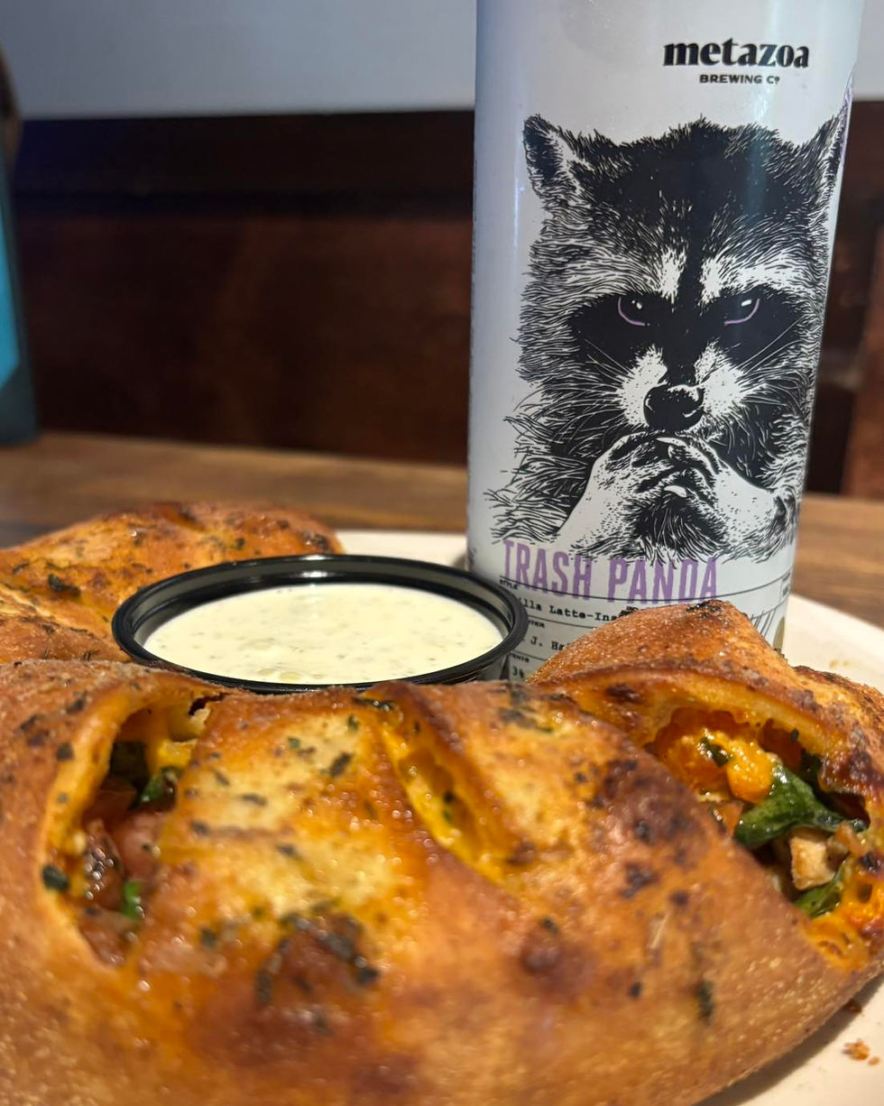 Saints Calzone with a can of Trash Panda beer