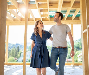 Wife and husband visiting building site of their new house with construction in background