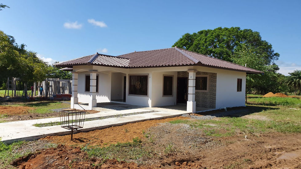 a white house with a brown roof is being built