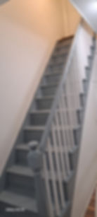 Indoor staircase with grey steps and white banister