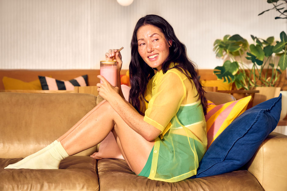 High-end commercial retouching of a woman relaxing on a sofa with Vital Proteins wellness products.