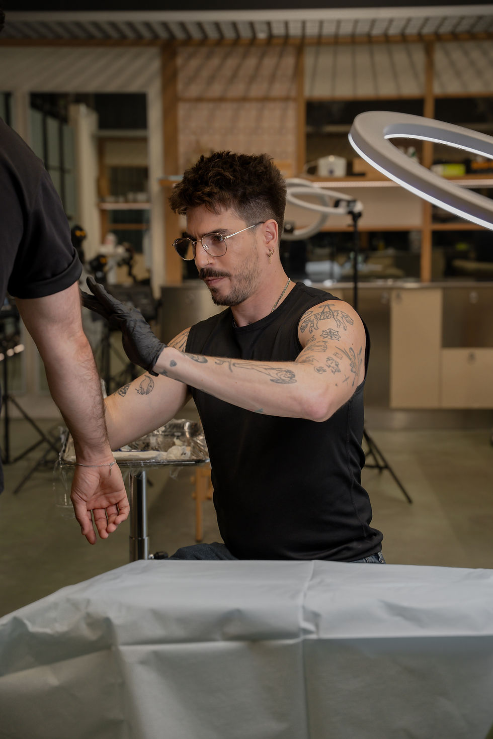 Tattoo artist working on a client's arm