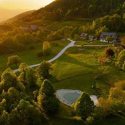 Veduna Retreat-Zentrum in grüner Hügellandschaft in Slowenien mit See – Rückzugsort für Retreat und innere Einkehr.