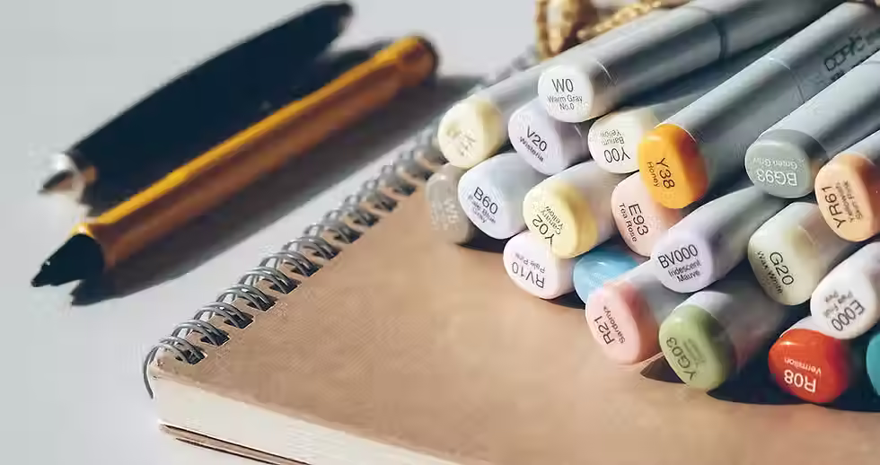 A note book with coloured pens