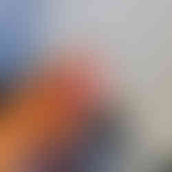 pink crochet bird in front of plants held in a hand