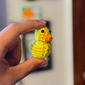 Tiny crochet duck in hand